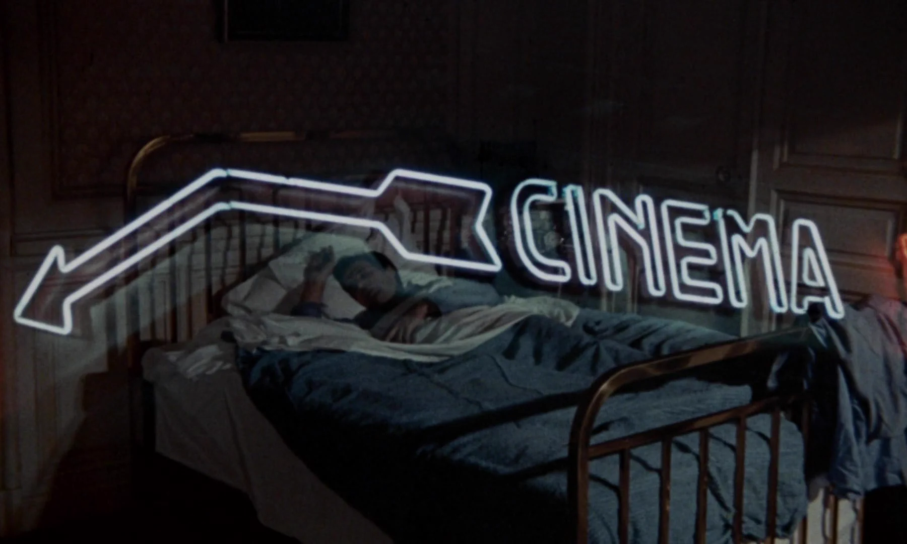 La scritta “Cinema” in un’insegna illuminata al neon, con una freccia